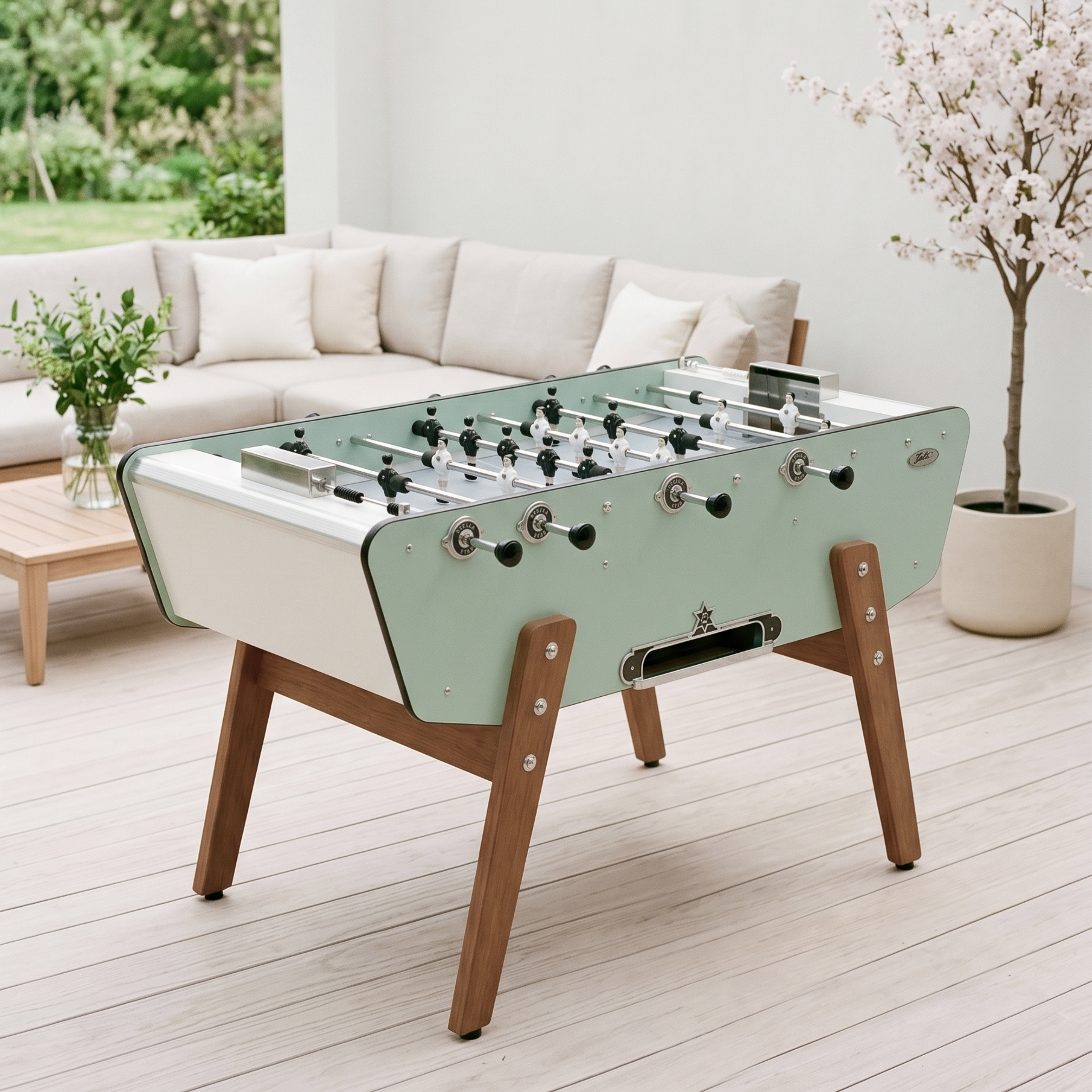 Baby-foot d'extérieur Stella Star Outdoor vert Belle-Île installé sur une terrasse, coloris nature et apaisant pour une expérience de jeu en plein air au cœur du jardin.